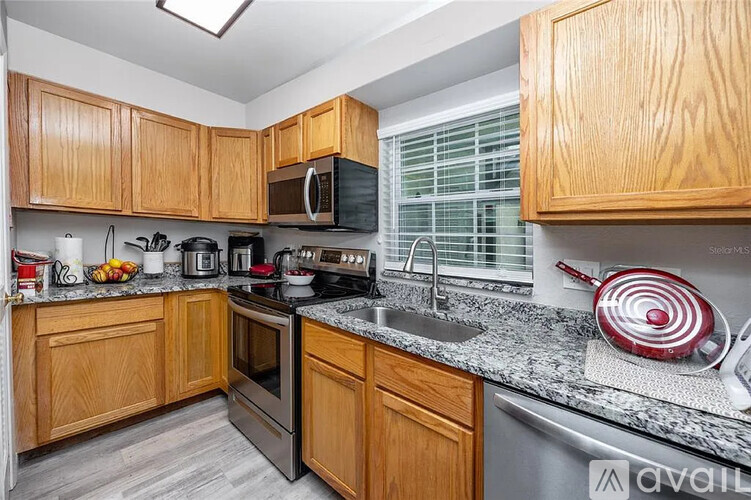 A kitchen with wooden cabinets and granite countertops.