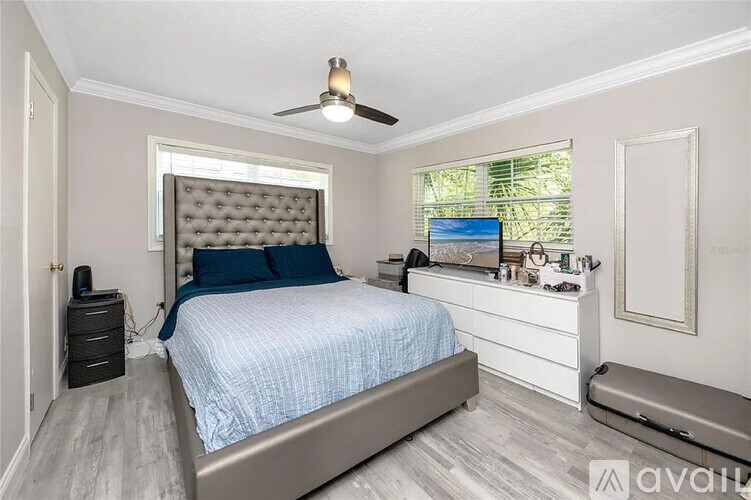 A bedroom with a bed, nightstand, and window.