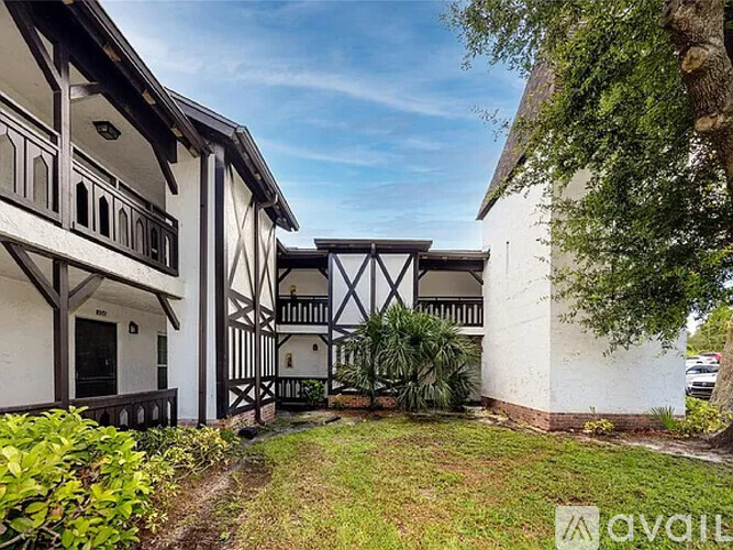 A white building with black timber framing and a balcony.