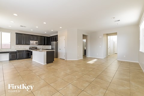 A spacious kitchen with black cabinets and white appliances.