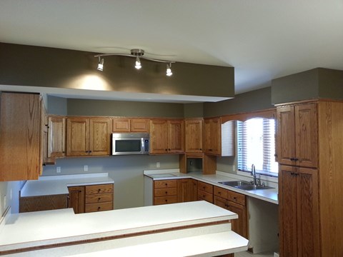 A kitchen with wooden cabinets and a white countertop.