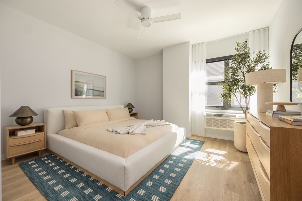A bedroom with a large bed and a ceiling fan.