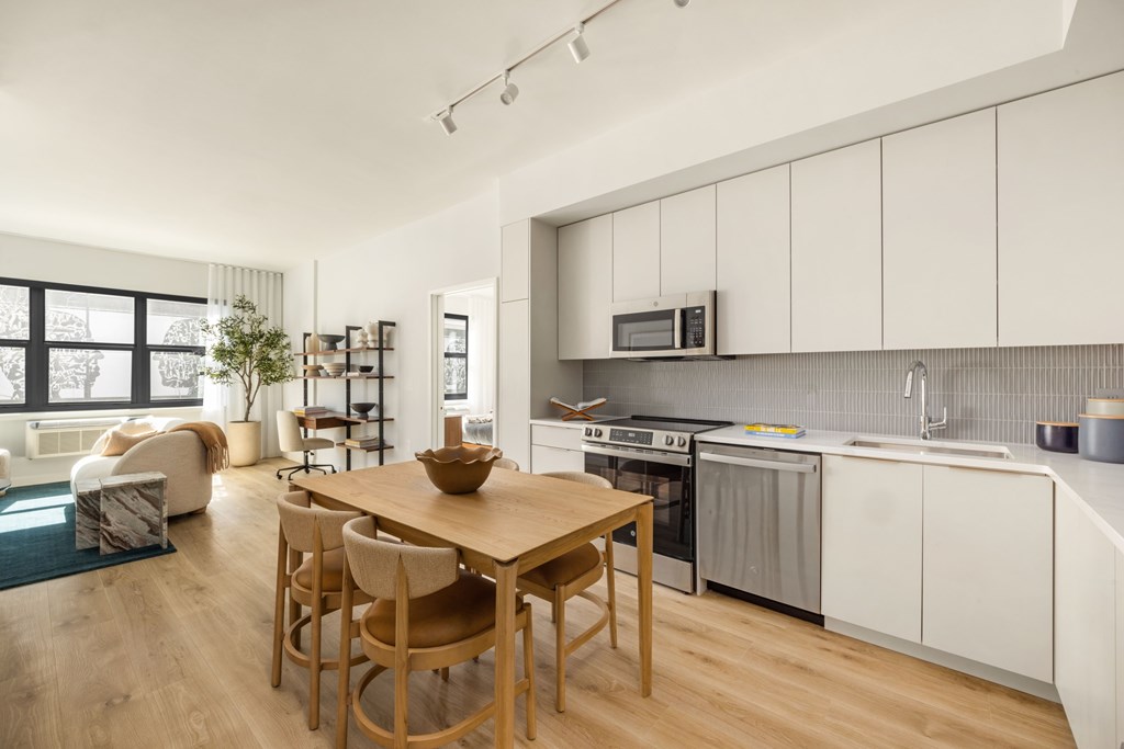 A modern kitchen with a wooden table and chairs.