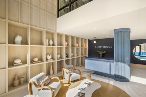 A living room with a sofa and a shelf with vases.