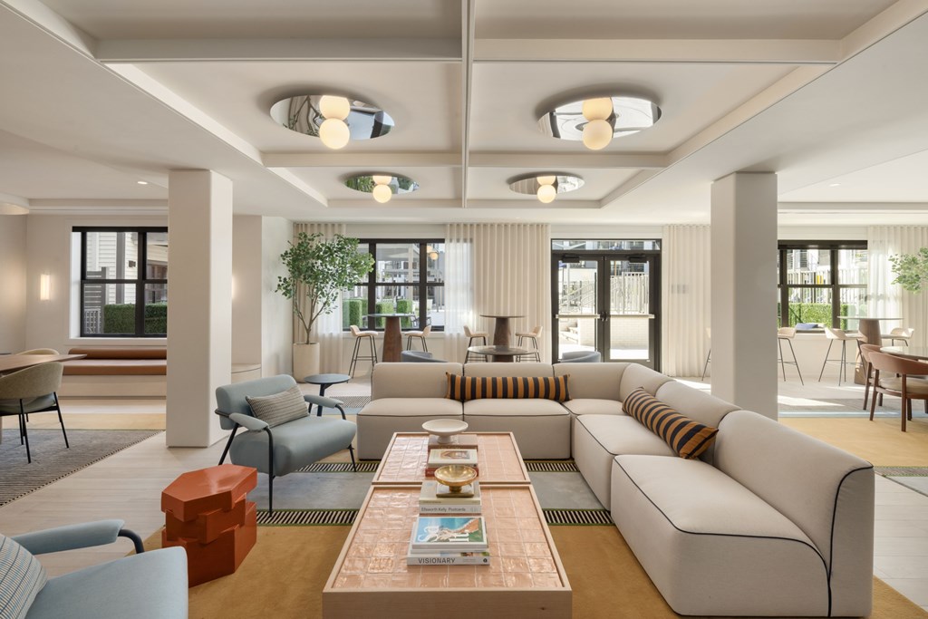 A modern living room with a large sofa, armchairs, and a coffee table.
