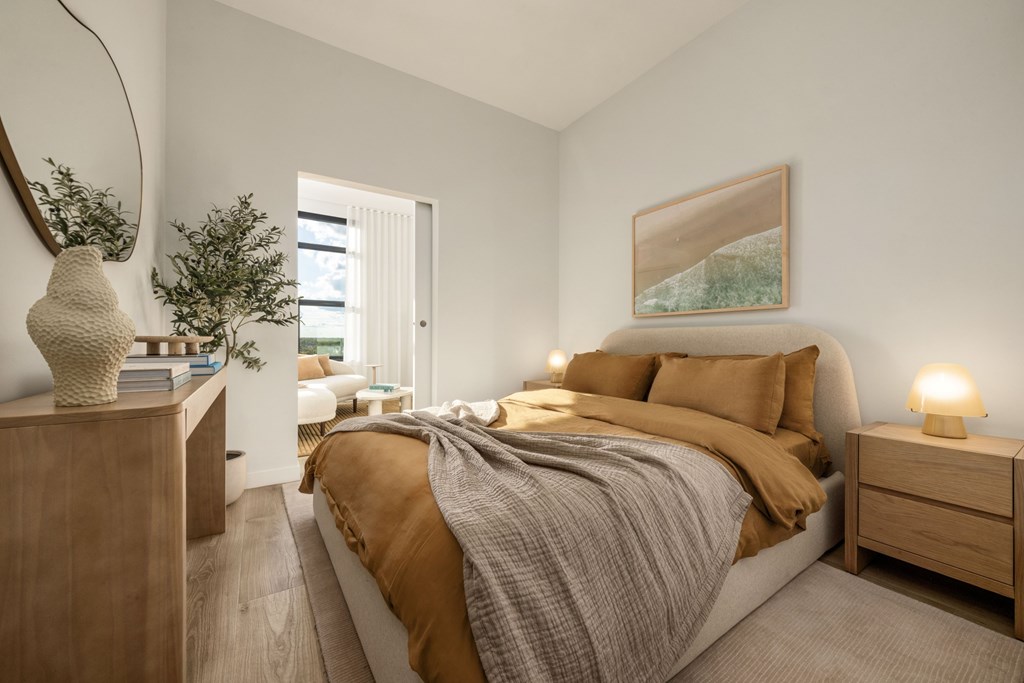 A bedroom with a bed, nightstand, and a painting on the wall.