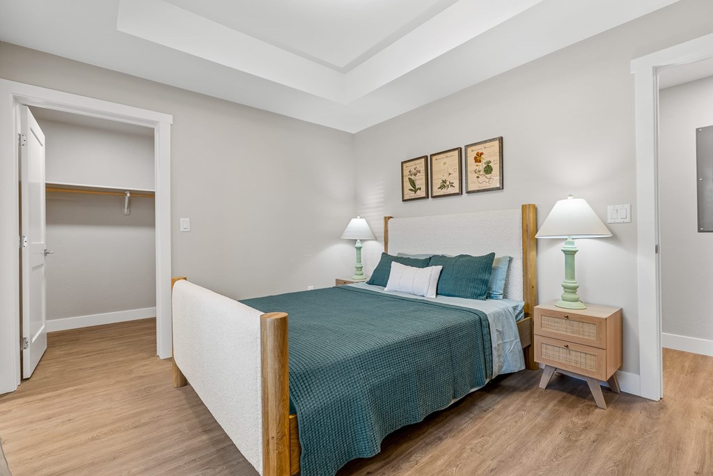 A bedroom with a bed, nightstand, and lamp.