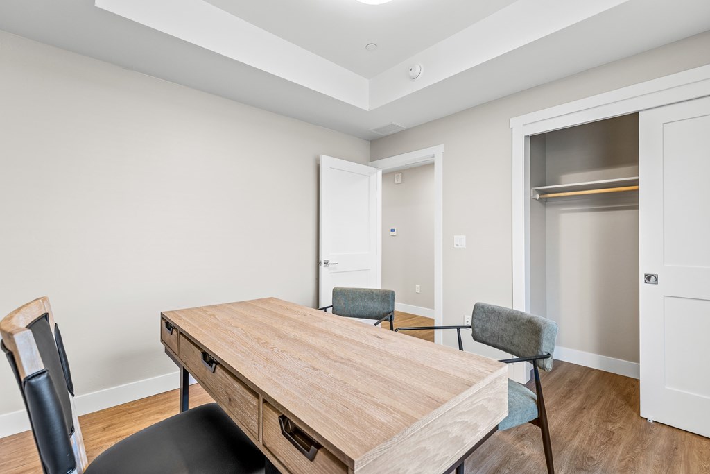 A room with a wooden table and chairs.
