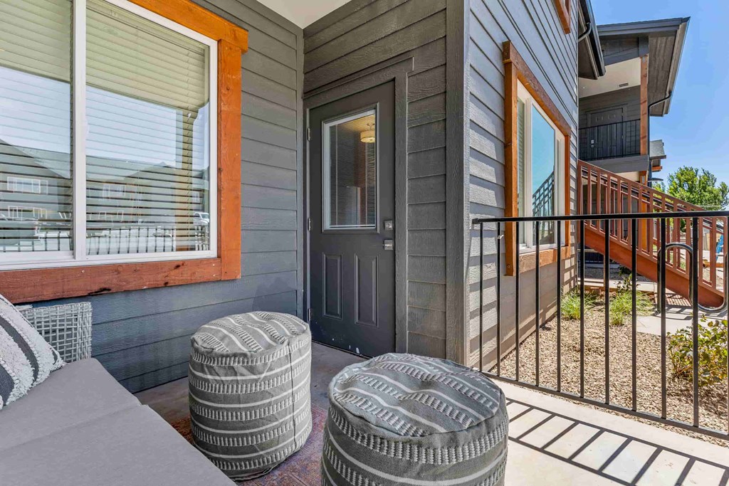 A grey house with a black door and a black fence.