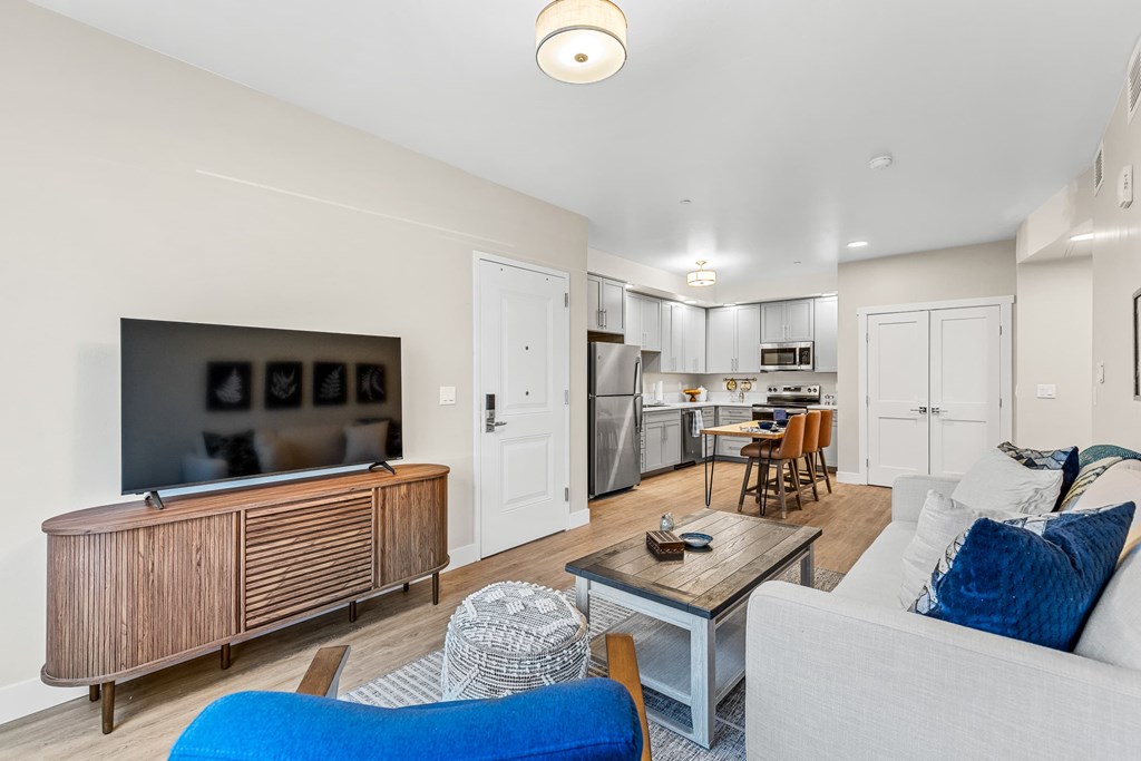 A living room with a white couch and a wooden cabinet.