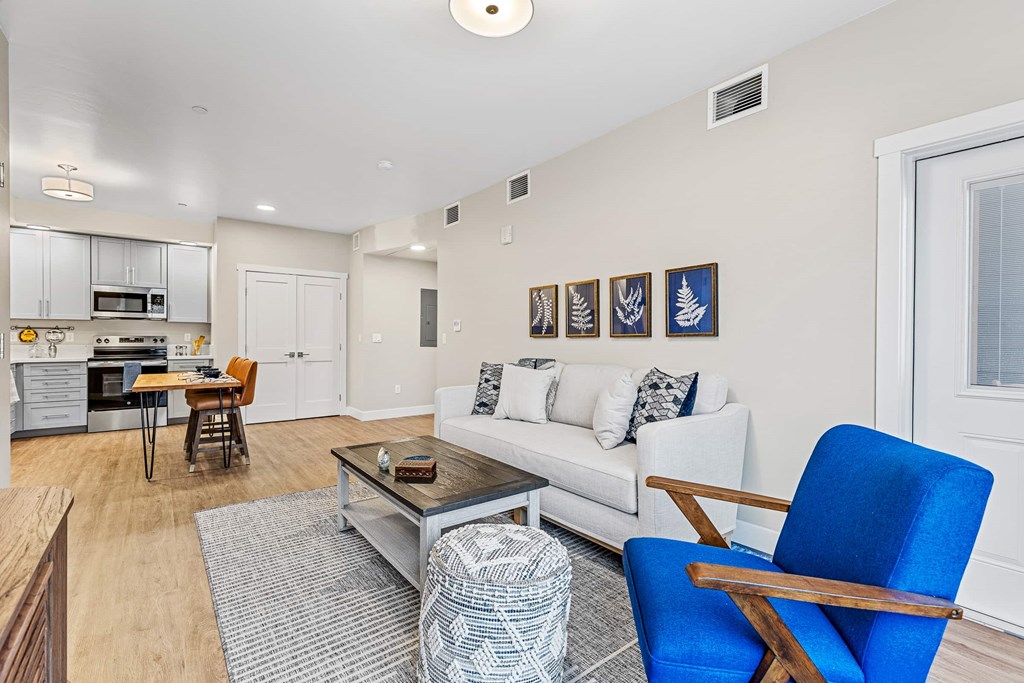 A living room with a white couch and a blue chair.