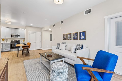 A living room with a white couch and a blue chair.