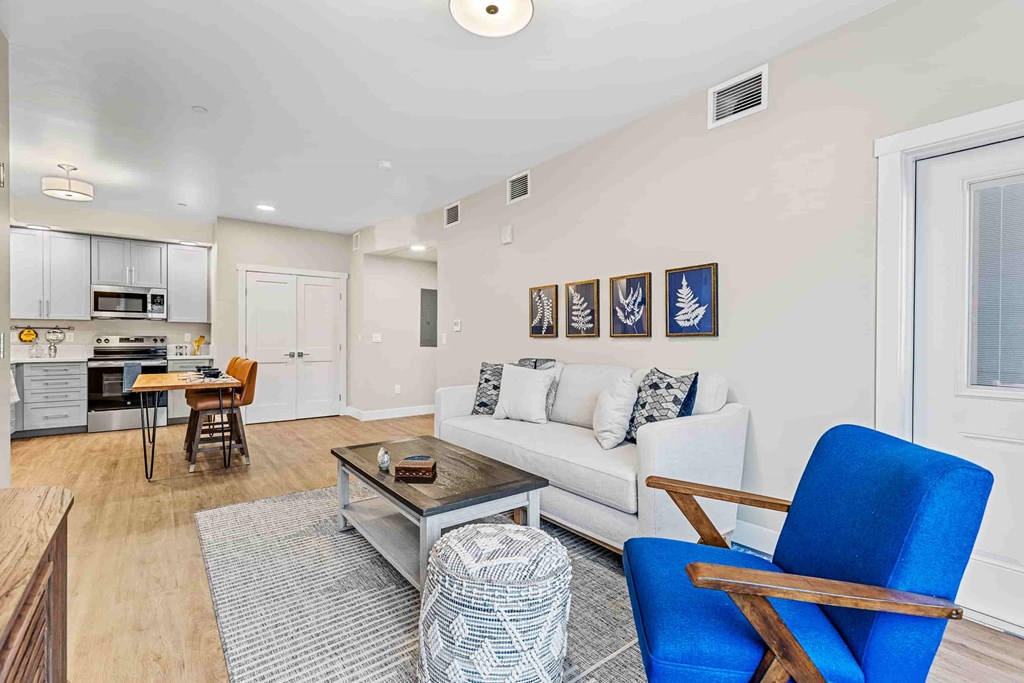 A living room with a white couch, a blue chair, and a coffee table.