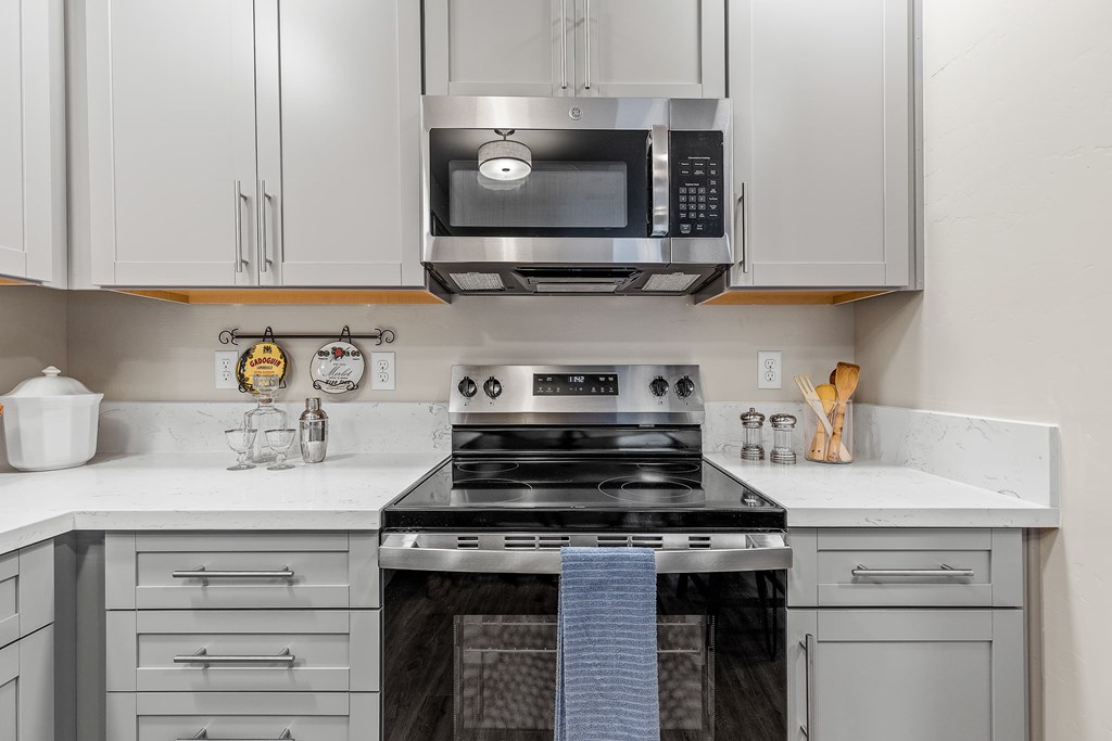 A modern kitchen with a stove top oven and microwave above it.