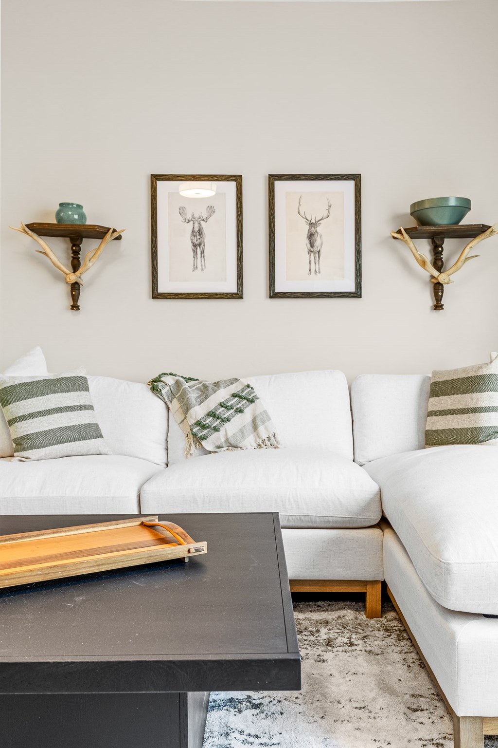 A white couch with a black coffee table in front of it.