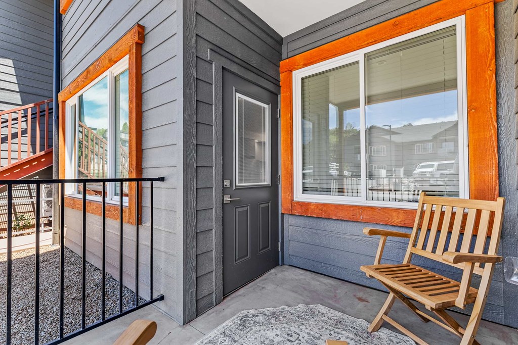 A wooden chair is placed on a porch.