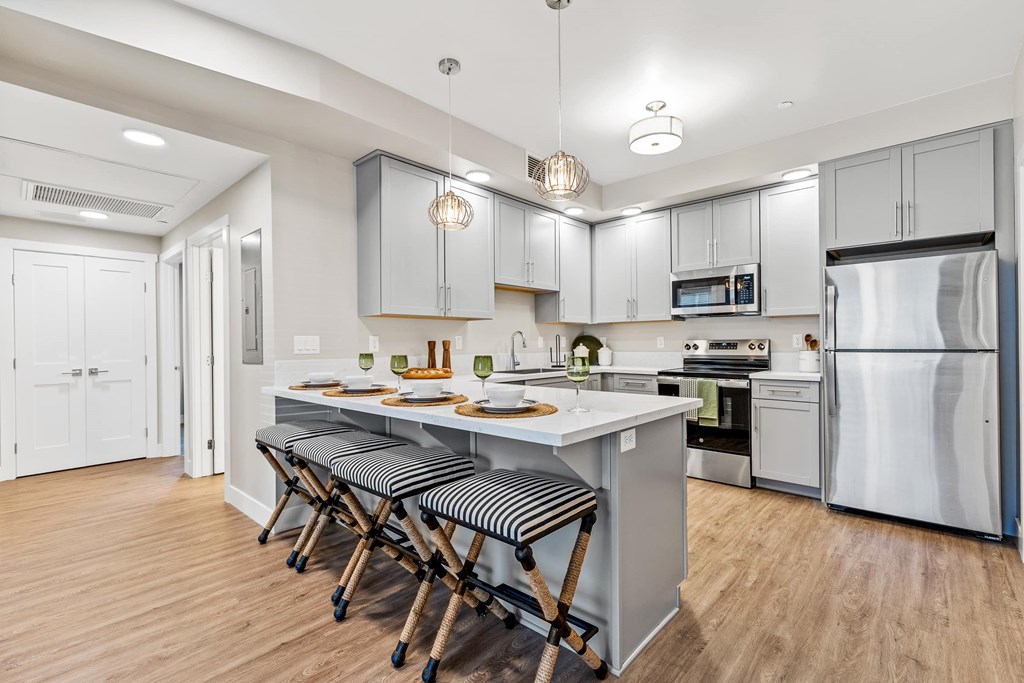 A modern kitchen with a long island and stools.