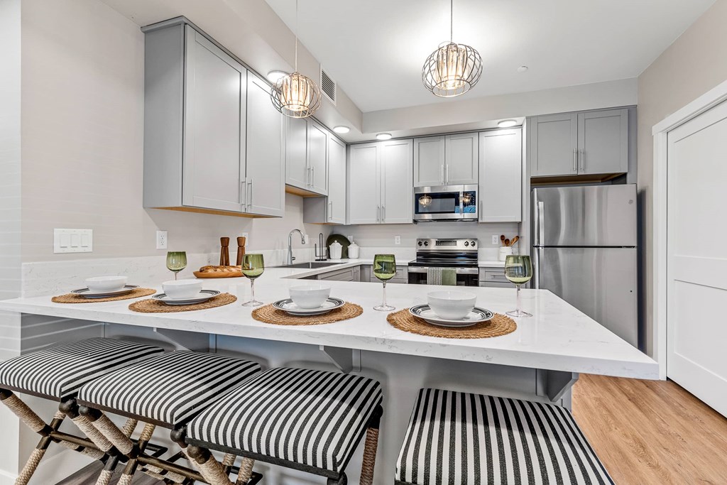 A modern kitchen with a dining table set for two.