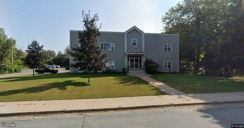 A grey house with a white door and windows.