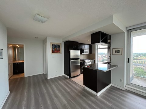 A modern kitchen with a black countertop and stainless steel appliances.