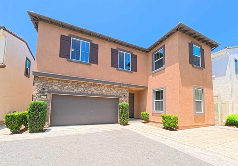 A two-story house with a garage and a driveway.