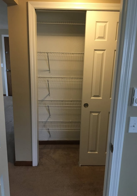 A white door with a shelf underneath it.