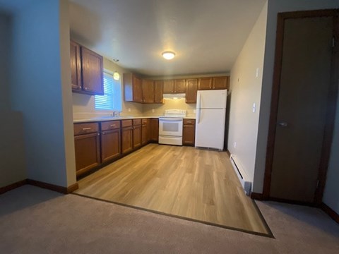 A kitchen with wooden cabinets and a white fridge.