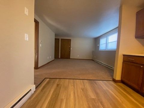 A room with wooden flooring and a window.