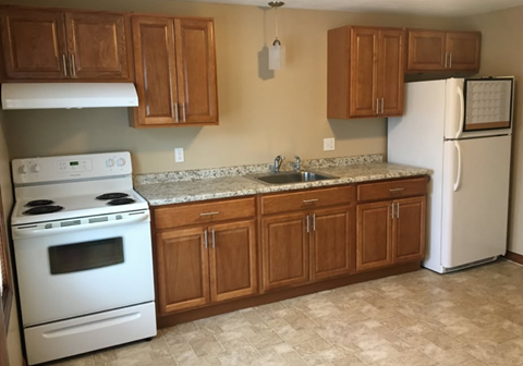 A kitchen with a white stove and a white refrigerator.