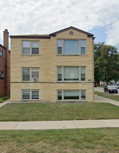 A brick building with a green lawn in front.