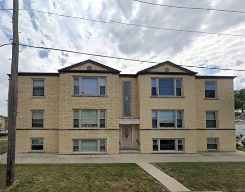 A two-story brick building with a front porch.
