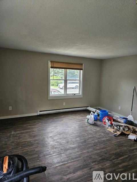 A room with a window and a vacuum cleaner on the floor.
