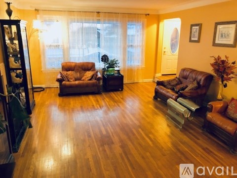 A living room with brown leather furniture and wooden floors.