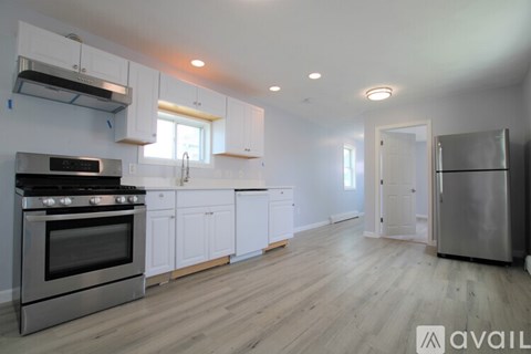 A kitchen with white cabinets and a stainless steel refrigerator.