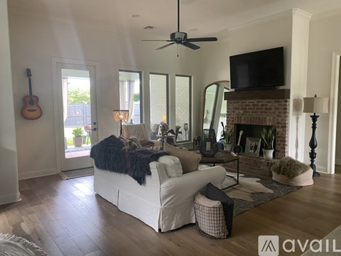 A living room with a white couch and a fireplace.