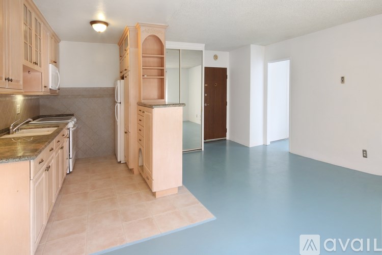 A kitchen with wooden cabinets and a refrigerator.