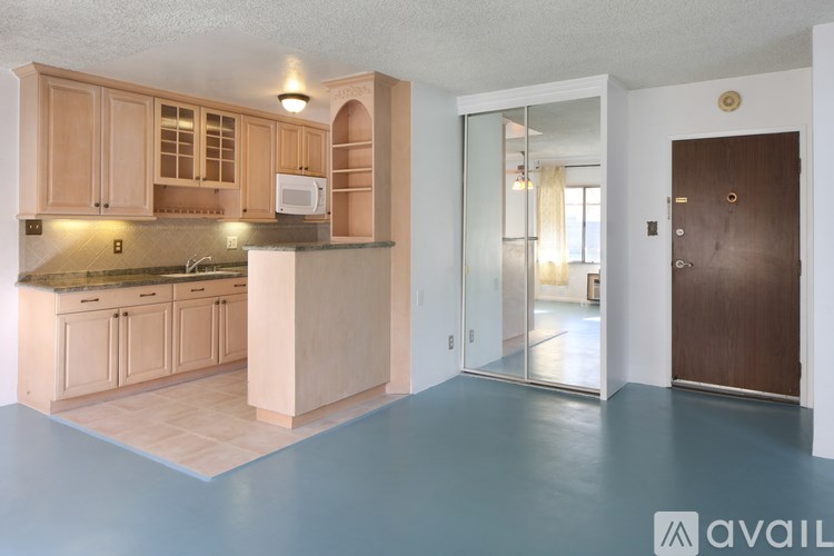 A kitchen with wooden cabinets and a countertop with a sink.