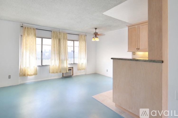 A room with a kitchen island and a window with curtains.