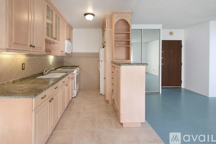 A kitchen with wooden cabinets and a marble countertop.