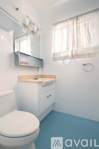 A white toilet sits next to a sink in a bathroom.