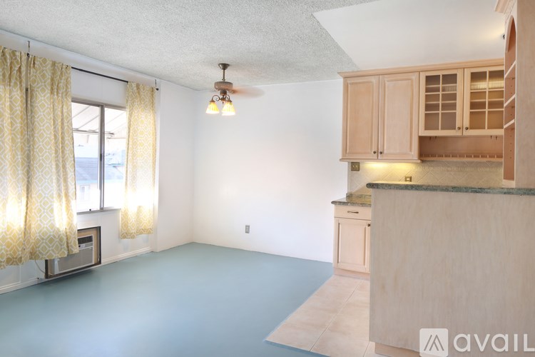 A kitchen with wooden cabinets and a ceiling fan.