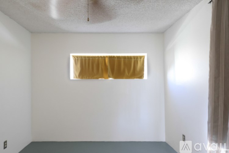 A room with a window covered in gold curtains.