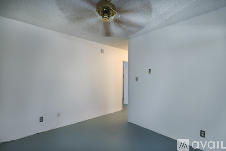 A room with a ceiling fan and a door.