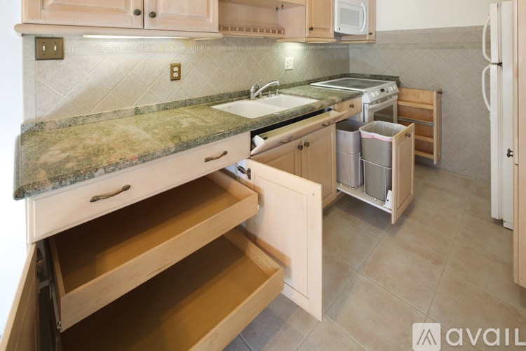 A kitchen with a granite countertop and wooden cabinets.