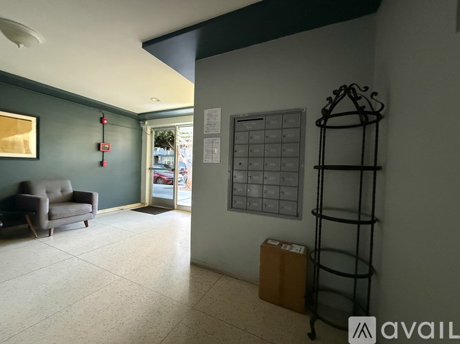 A hallway with a chair, a rack, and a calendar on the wall.