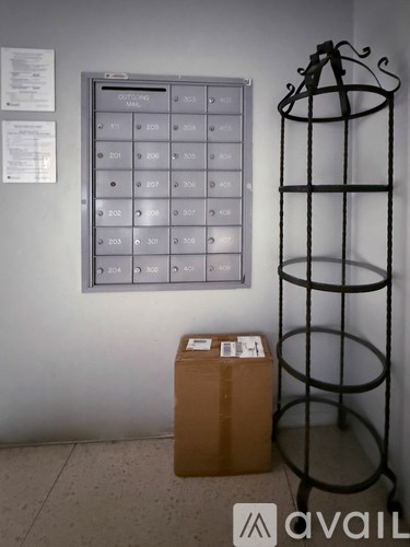 A cardboard box is sitting on the floor next to a tall black rack.