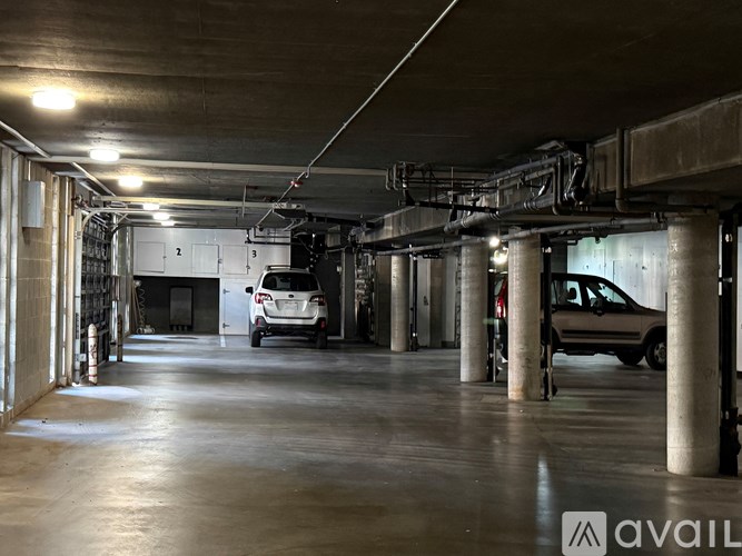 A parking garage with a white van and a brown car parked inside.