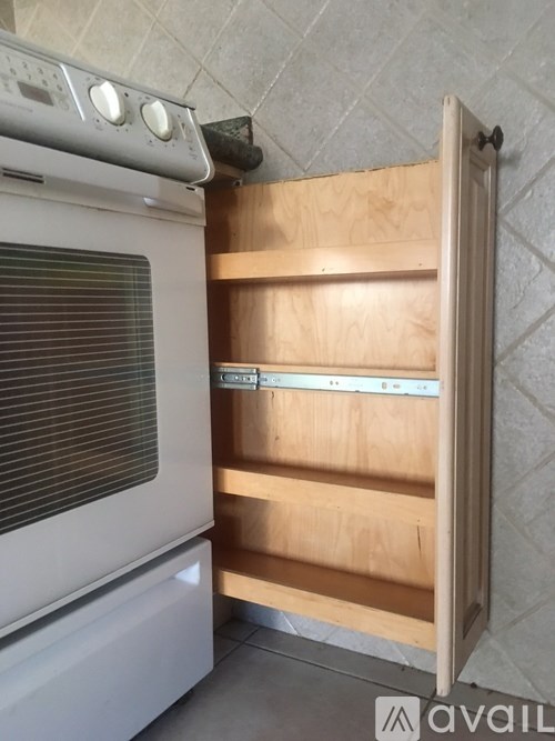 A white oven with a wooden door and a tile wall.