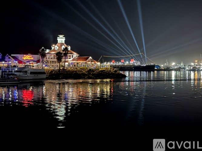 A nighttime view of a waterfront with a building and boats.