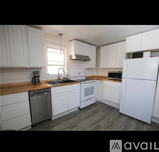 A kitchen with white cabinets and appliances.